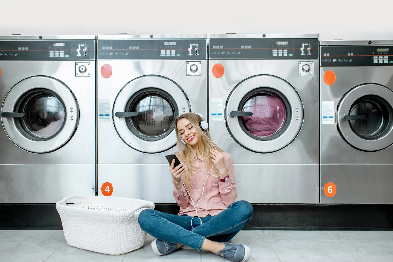 Customer waiting beside the washing machines at WhizzFix self-service laundry in St Julian's